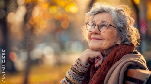 Elderly woman enjoying a peaceful moment in a park during autumn, surrounded by colorful foliage and warm sunlight