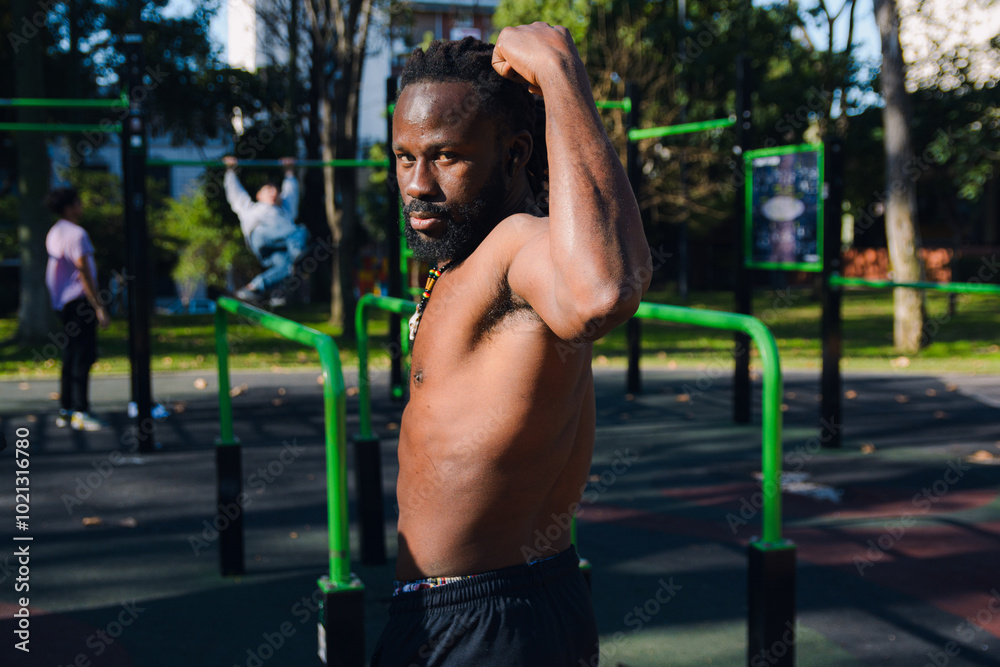 Side view of black Man looking at camera posing showing his strength Side view of black Man looking at camera posing showing his strength