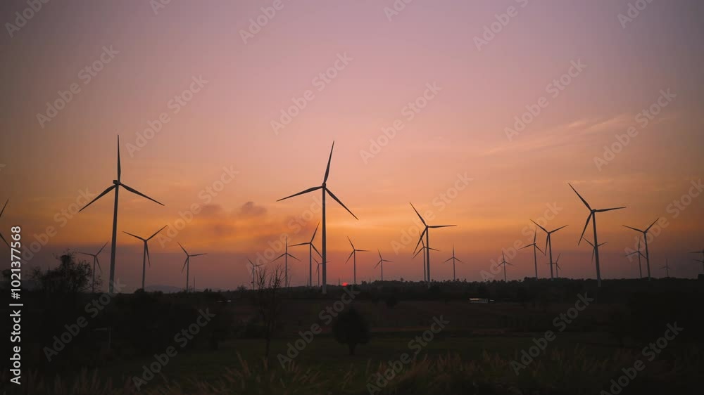 Beauty in nature of the windmill farm at sunset with the golden light of the sun beautiful. Renewable energy and green clean energy are environment friendly. Wind turbine for electric power ecology. Beauty in nature of the windmill farm at sunset with the golden light of the sun beautiful. Renewable energy and green clean energy are environment friendly. Wind turbine for electric power ecology.