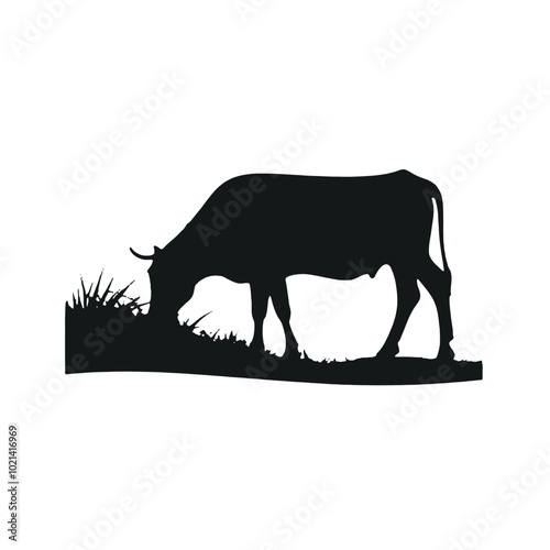A black silhouette of a cow grazing in a grassy field