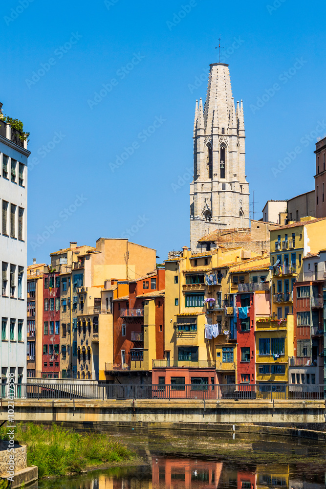 Obraz premium Clocher de style gothique de la Basílica Sant Feliu de Gérone dominant le Riu Onyar et ses immeubles colorés