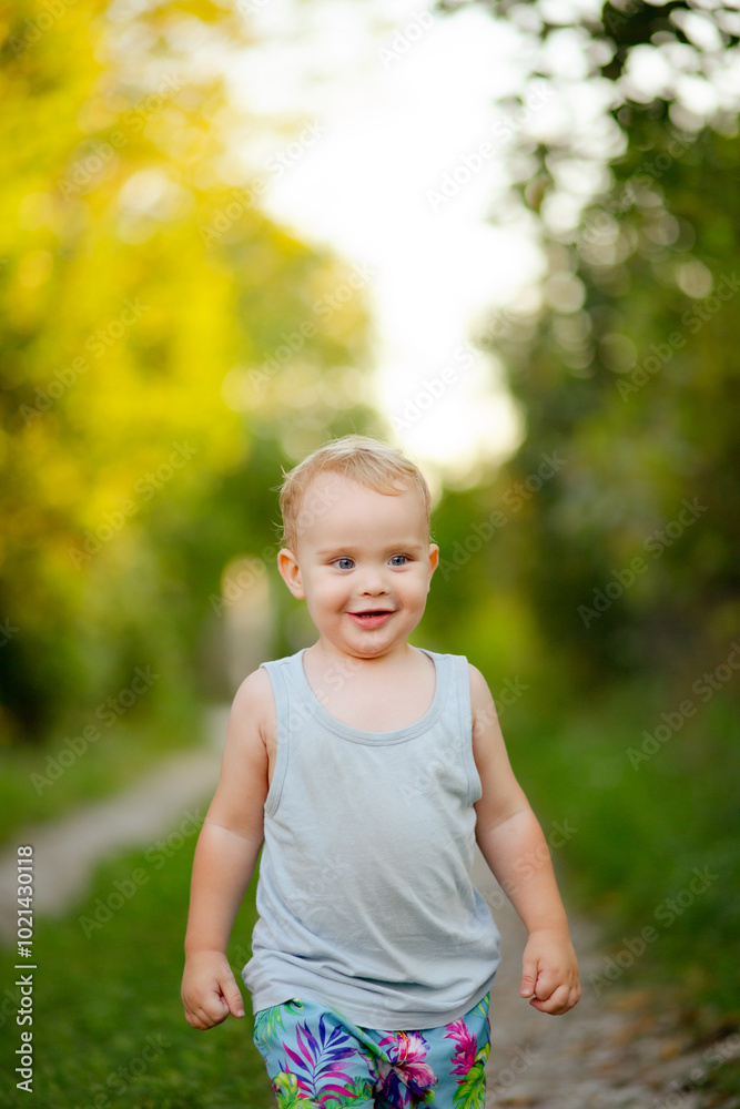 small happy boy walking in the country yard among the greenery, childhood in summer small happy boy walking in the country yard among the greenery, childhood in summer