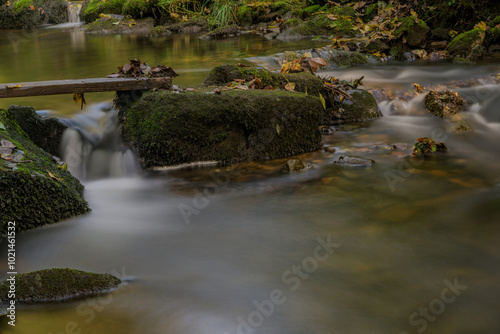 Langzeitbelichtung eines kleinen Wasserfalls im Wald photo