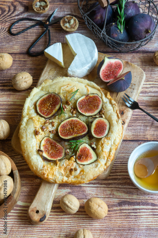 Pie with figs and cheese, as well as nuts and cheese on the table. Pie with figs and cheese, as well as nuts and cheese on the table.