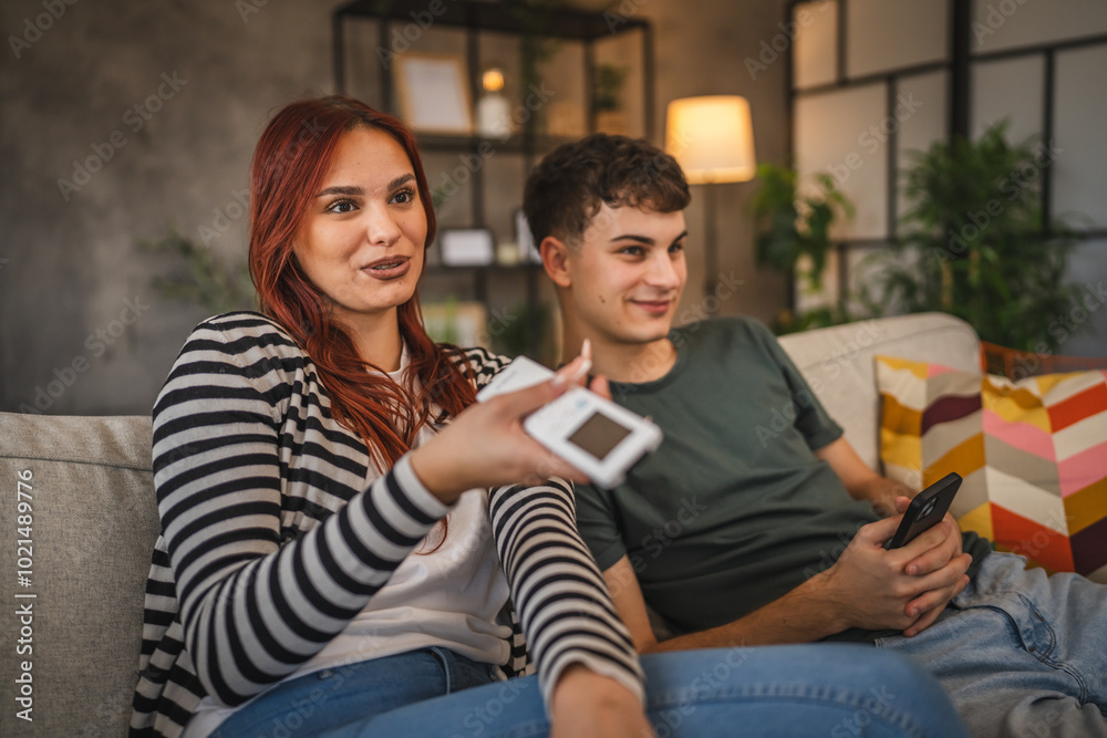 Young couple girlfriend watch movie while boyfriend use cellphone Young couple girlfriend watch movie while boyfriend use cellphone