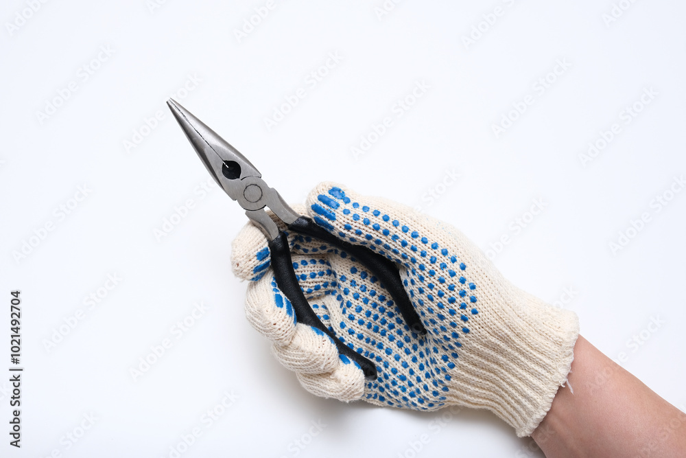 Obraz premium A person is holding a pair of blue and white gloves and a pair of pliers. The gloves are blue and white with black dots. Concept of caution and safety