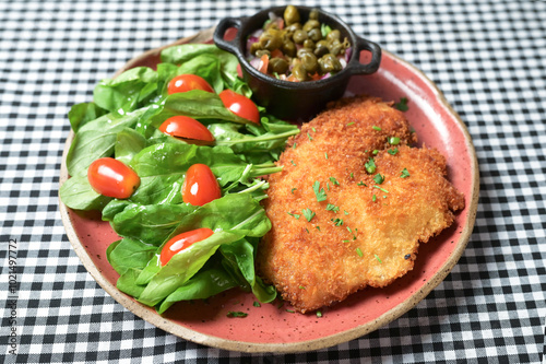 plate of food with chicken breast salad and caper sauce fish and chicken fillet photo