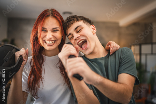 Girlfriend hug boyfriend while he sing on microphone on karaoke party