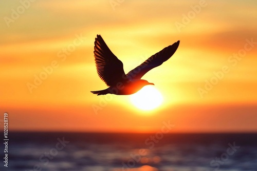 a bird flying over the ocean at sunset