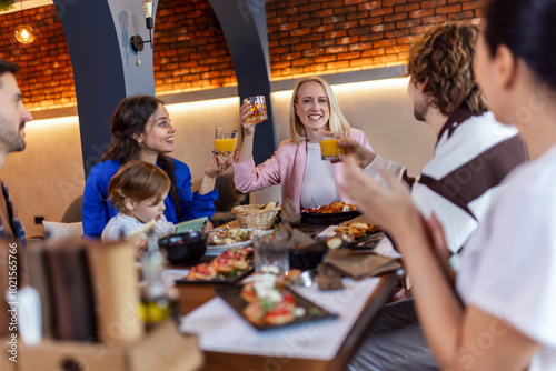 Family and friends gathered in a restaurant to eat delicious food, talk, drink and hang out.