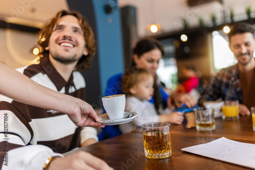 Waiter bringing coffee to his customer in a restaurant.