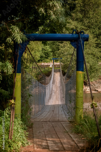Empty pedestrian bridge suspended over the river in the Carpathians, Iltsy, V...