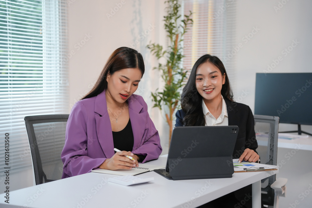 Two businesswomen are having a productive meeting in the office, discussing a new project Two businesswomen are having a productive meeting in the office, discussing a new project