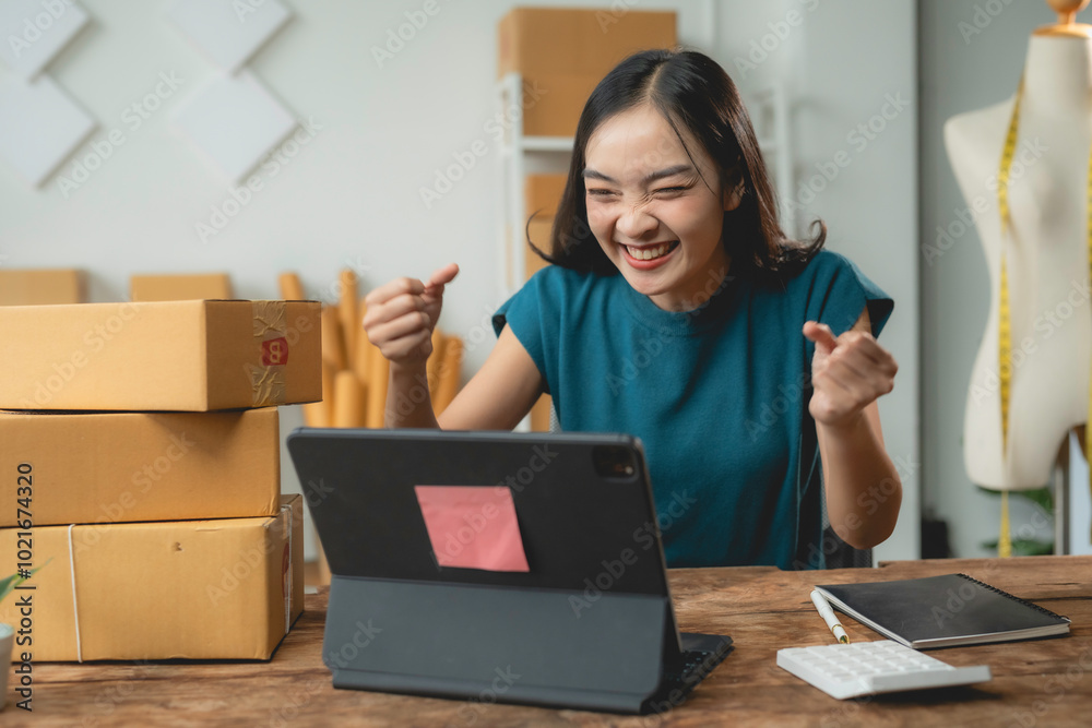 Asian sme business owner is celebrating a business success while looking at her tablet Asian sme business owner is celebrating a business success while looking at her tablet