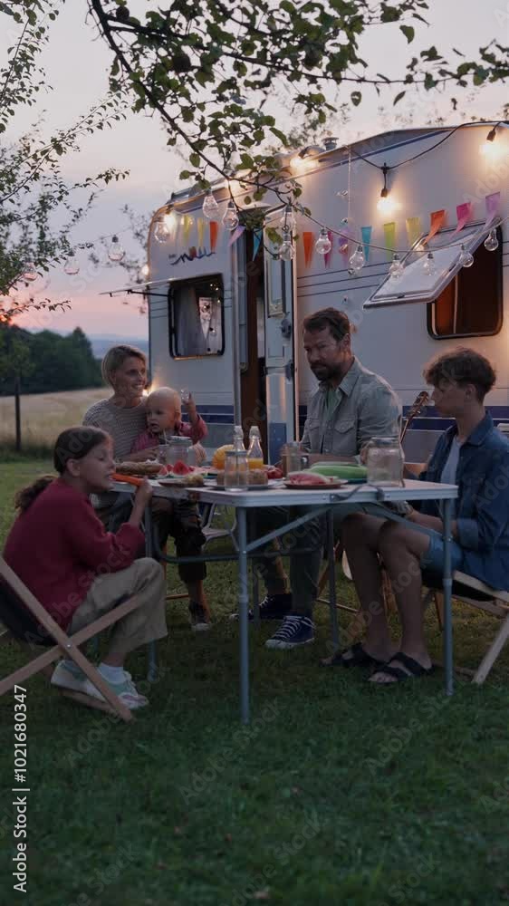Family traveling in caravan, having picnic diner. Parents with three kids during camping trip. Family traveling in caravan, having picnic diner. Parents with three kids during camping trip.