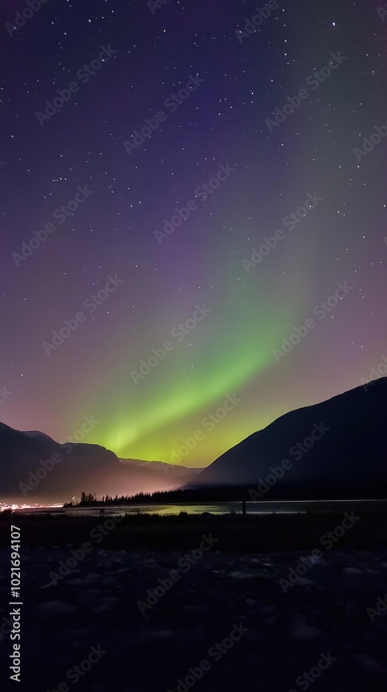 Experiencing the magical northern lights illuminating the night sky with vibrant green and purple colors over mountain landscape Experiencing the magical northern lights illuminating the night sky with vibrant green and purple colors over mountain landscape