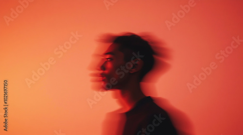 A silhouette of a person against a red light background, creating a blurring effect
