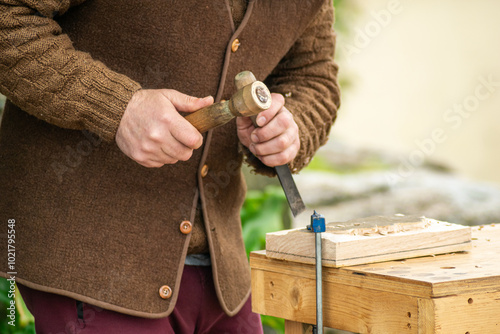 a craftsman working wood in the traditional antique style at an ethnological festival in Galicia photo