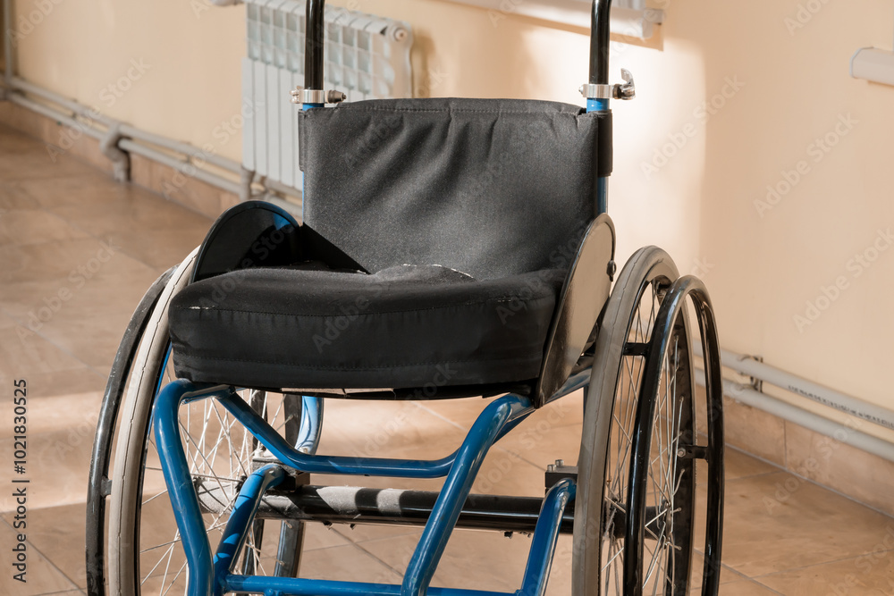 Fototapeta premium A Quiet Moment: An Abandoned Wheelchair in Sunlit Corridor