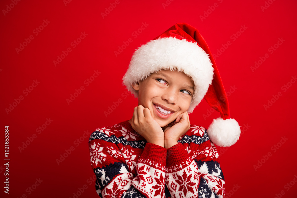 Photo portrait of charming small boy look dreamy empty space celebrate christmas dressed knitted sweater isolated on red color background Photo portrait of charming small boy look dreamy empty space celebrate christmas dressed knitted sweater isolated on red color background