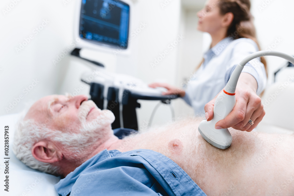 Cropped photo of a senior male patient heart examination with ultrasound by woman doctor Cropped photo of a senior male patient heart examination with ultrasound by woman doctor