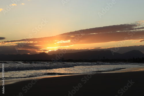 Sunset at sea. Balearic Sea, Salou, Spain. Beach, sea, small waves. Evening landscape on the coast. Vacation at sea