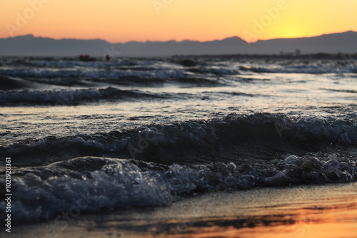 Sunset at sea. Balearic Sea, Salou, Spain. Beach, sea, small waves. Evening landscape on the coast. Vacation at sea