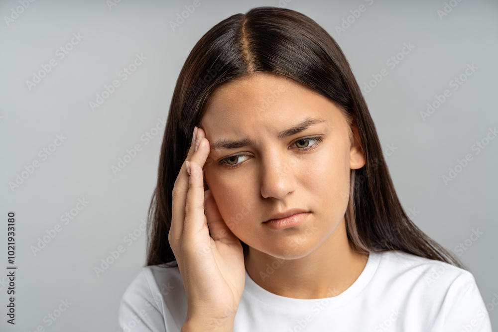 Distressed teen girl covers face, nearly in tears against grey wall. Overwhelmed by school stress, sleepless nights, emotional trauma from bullying, abuse, feeling trapped, ashamed, deeply isolated Distressed teen girl covers face, nearly in tears against grey wall. Overwhelmed by school stress, sleepless nights, emotional trauma from bullying, abuse, feeling trapped, ashamed, deeply isolated