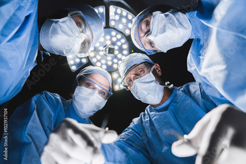 Low angle shot in operating room. Professional medical doctors performing surgery. photo