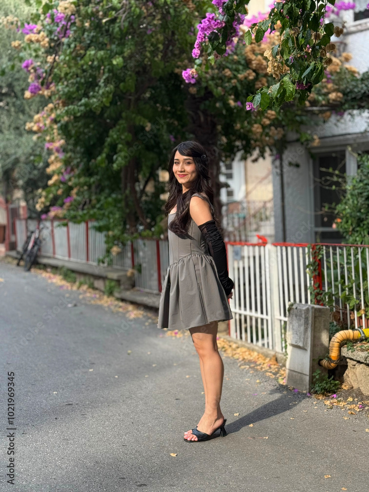 Brunette, beautiful, young girl smiling with a happy expression. Girl posing from the side and full length outdoors, on a street. Flirty, cute playful girl Brunette, beautiful, young girl smiling with a happy expression. Girl posing from the side and full length outdoors, on a street. Flirty, cute playful girl