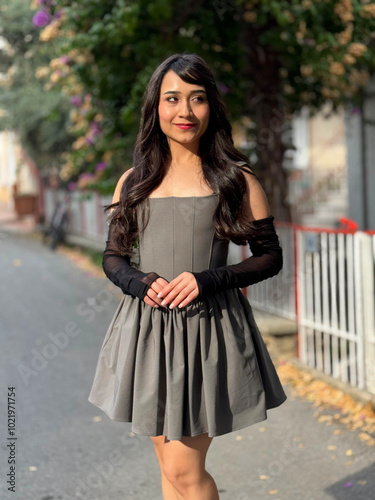 Young, brunette, beautiful girl posing for the camera with different emotions and expressions, outdoors, in fashionable clothes. Beautiful facial expressions of the cute girl with her hands clasped