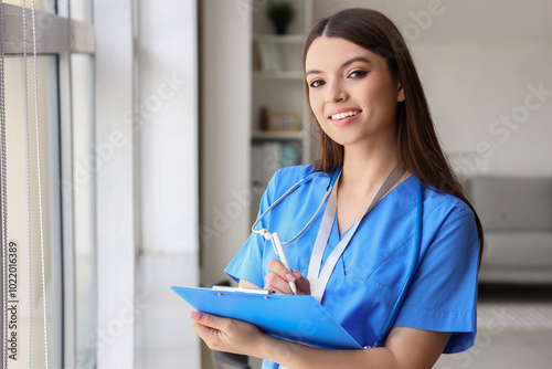 Female medical intern writi...