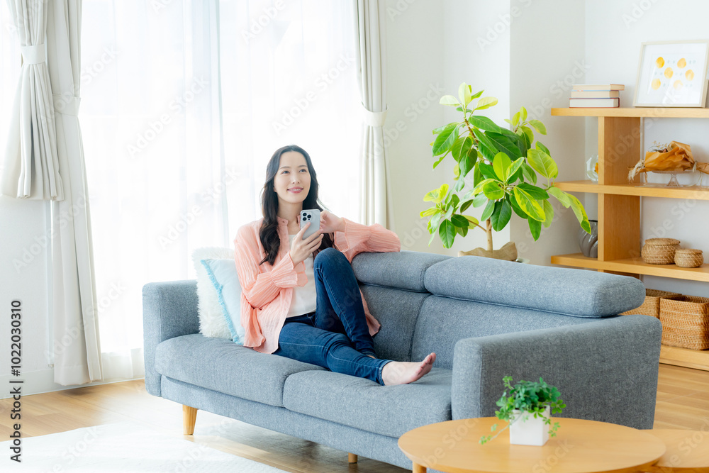 部屋でスマホを操作する女性 部屋でスマホを操作する女性