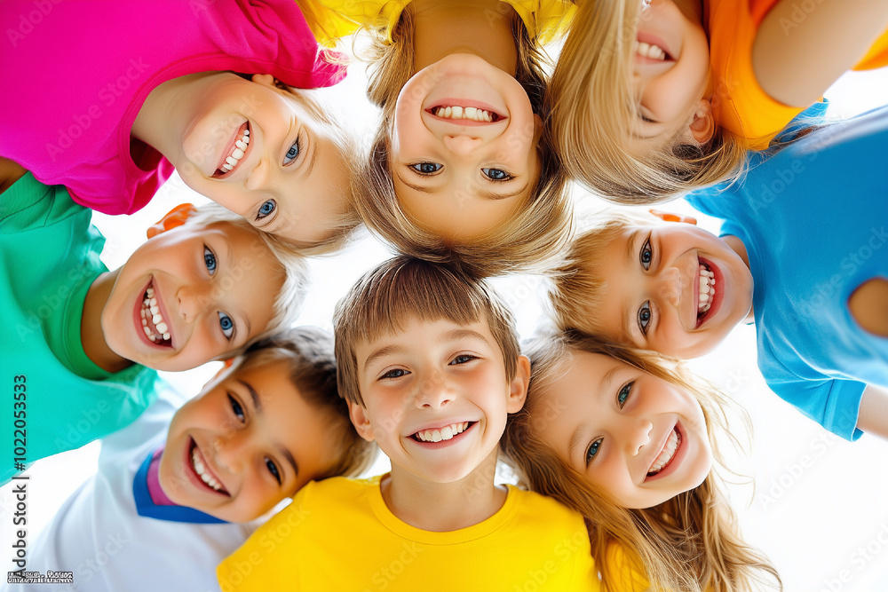 Childrens smiling in a huddle looking down in camera Childrens smiling in a huddle looking down in camera