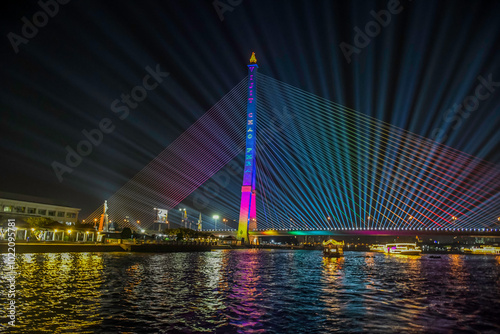 Neon lighting on Rama VIII Bridge on chao phraya river in Bangkok at night taken on dinner cruise