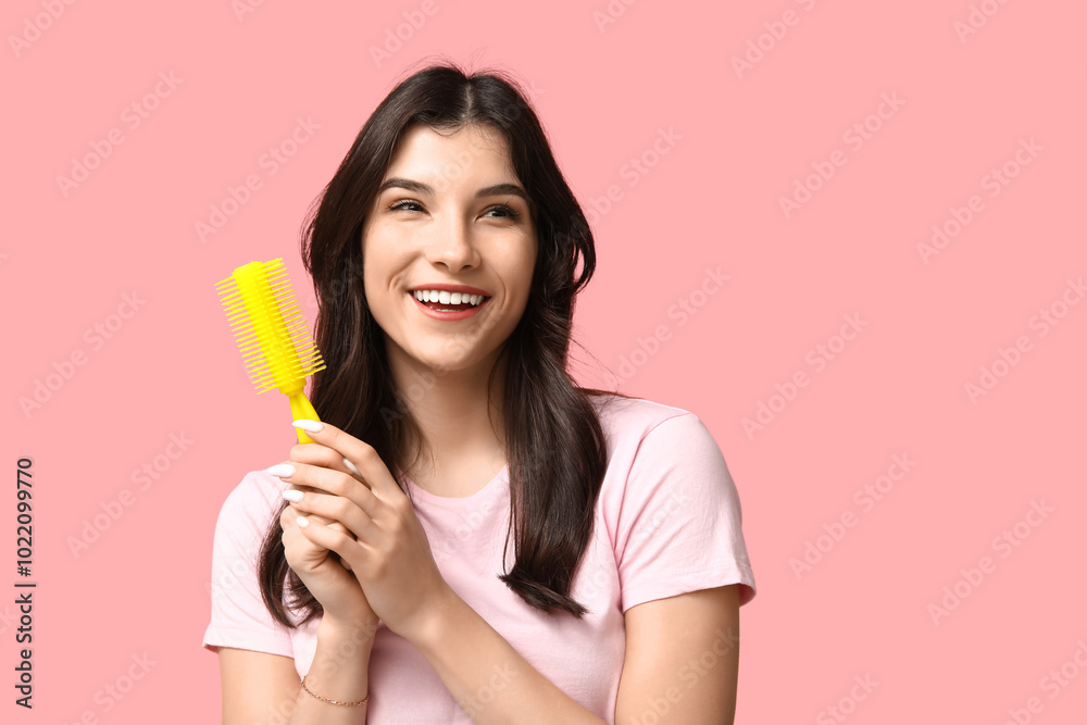 Beautiful young woman with yellow hair brush on pink background Beautiful young woman with yellow hair brush on pink background