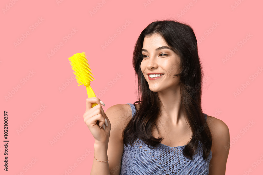 Beautiful young woman with yellow hair brush on pink background Beautiful young woman with yellow hair brush on pink background