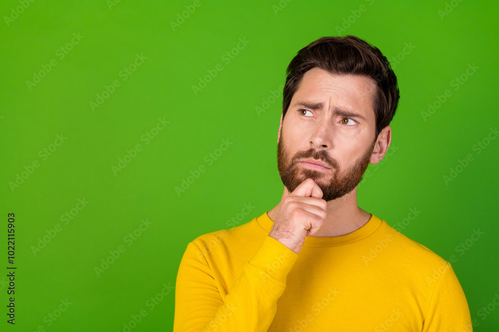 Photo of minded man with stylish beard dressed yellow shirt finger on chin look at logo empty space isolated on green color background Photo of minded man with stylish beard dressed yellow shirt finger on chin look at logo empty space isolated on green color background