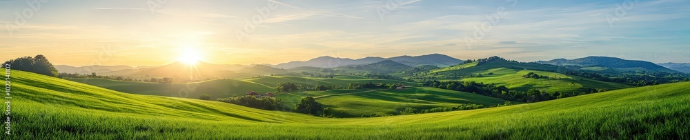 Obraz premium A breathtaking view of a serene sunrise illuminating lush green hills and meadows. The tranquil landscape evokes a sense of peace and connection to nature.