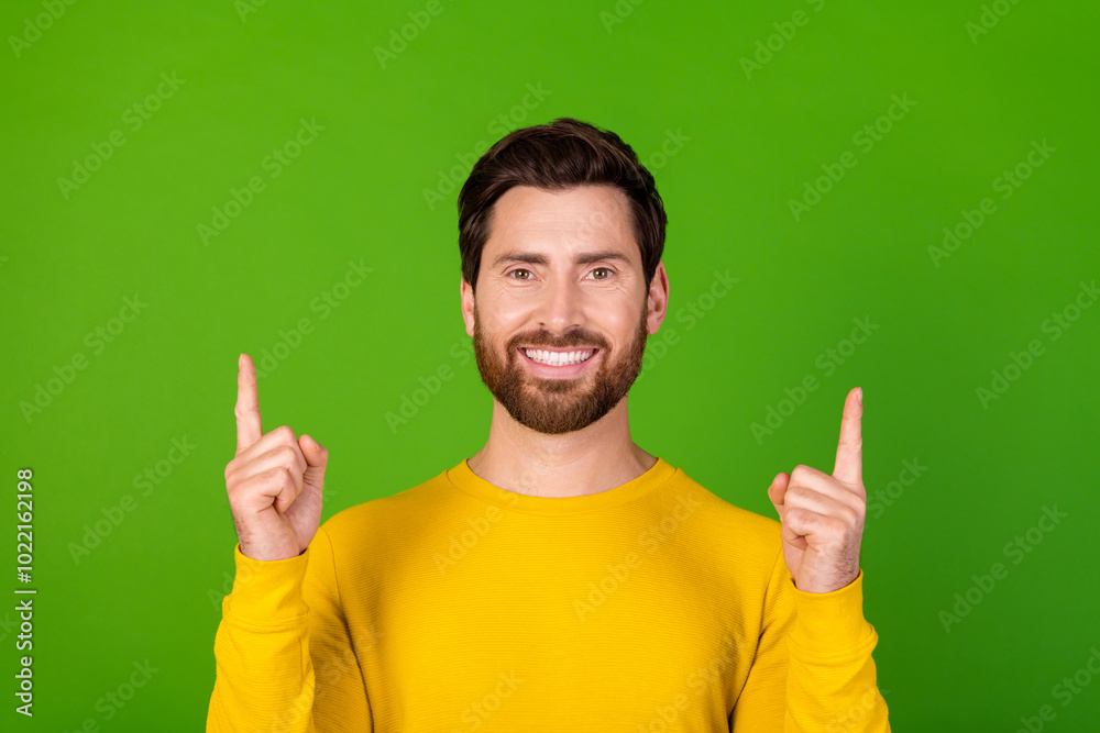 Photo portrait of pretty young male point up empty space wear trendy yellow outfit isolated on green color background Photo portrait of pretty young male point up empty space wear trendy yellow outfit isolated on green color background