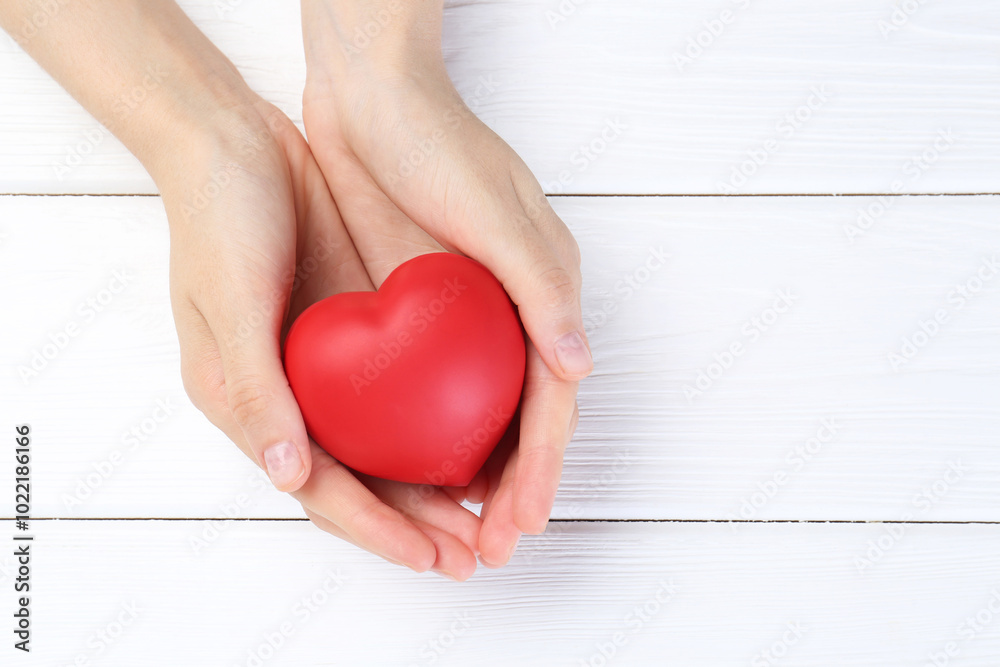 Woman holding red heart on white wooden background, top view. Space for text Woman holding red heart on white wooden background, top view. Space for text