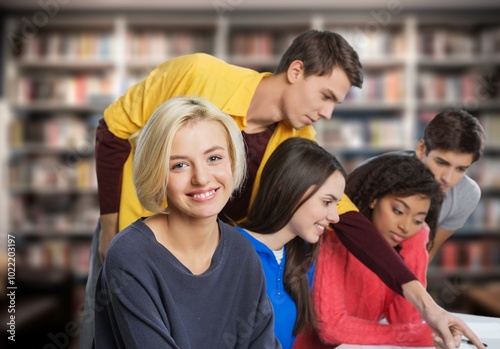 Happy young students learning at library for education