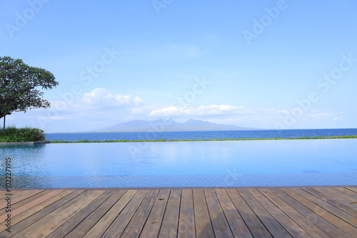 Blue water at infinity pool. Enjoying the view of sea and volcanic mountains in background. Concept blue nature web banner backdrop background graphic. 