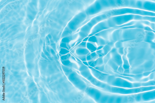 Blue water with ripples on the surface. Defocus blurred transparent blue colored clear calm water surface texture with splashes and bubbles. Water waves with shining pattern texture background.