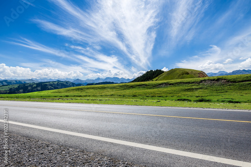 Obraz na płótnie Asphalt highway road and green grasslands with mountain natural landscape in summer. Road trip. w salonie