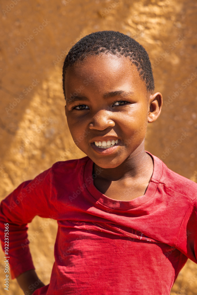 african village, single child girl standing in the yard , mud hut in the background african village, single child girl standing in the yard , mud hut in the background