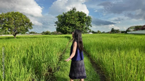 Beautiful thai farmer running  In the field at sunset.