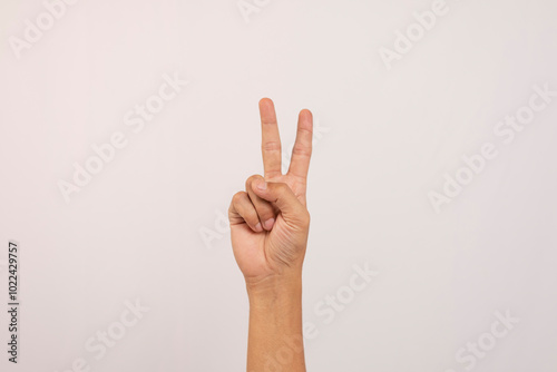 Close up of Caucasian male hand showing number two gesture isolated on white studio background. Hand number concept for people with disabilities.