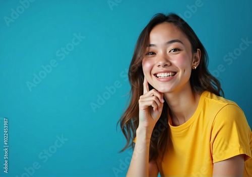 Smiling Woman in a Bright Yellow T-Shirt Against a Blue Background - A Casual and Vibrant Fashion Portrait