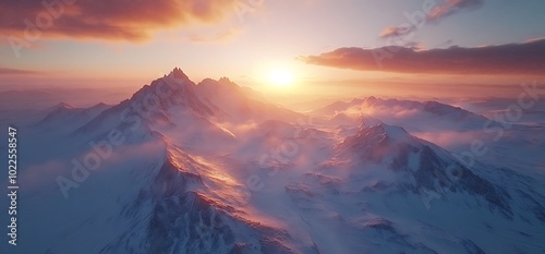 Mountain peaks at sunset with clouds and a golden sky.